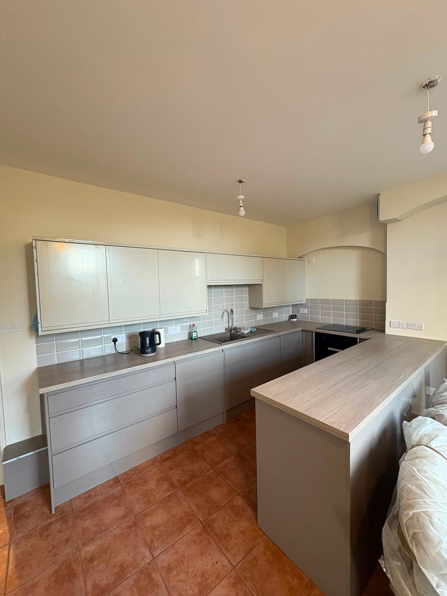 Fitted grey kitchen with laminate worktops and breakfast bar