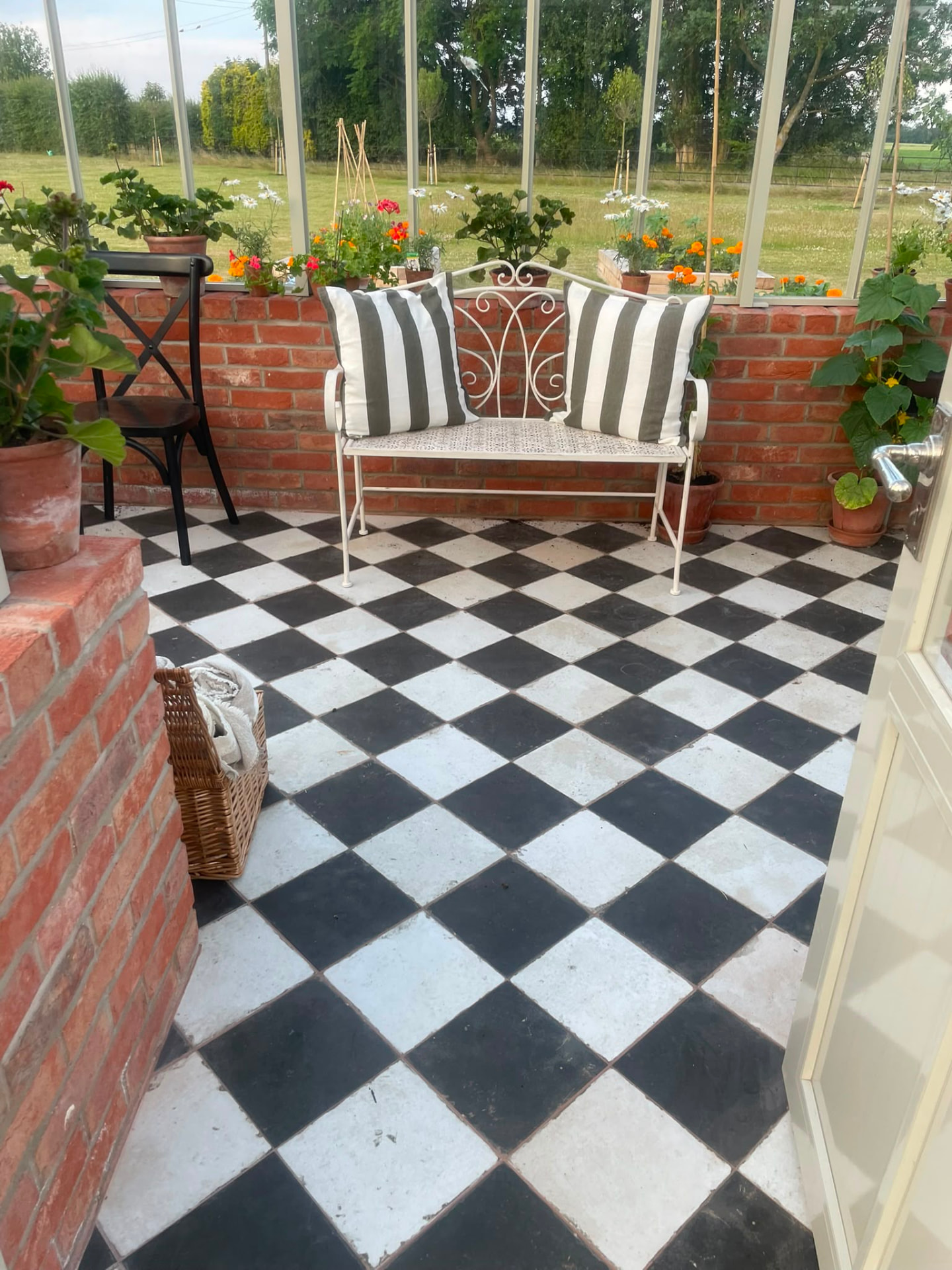 Glasshouse interior with black and white chequerboard tiled floor