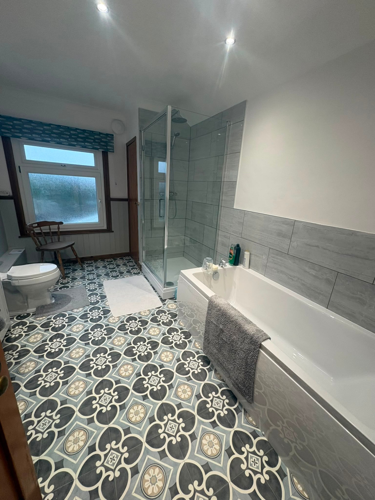 Modern fitted bathroom with bath, shower enclosure and patterned floor tiles
